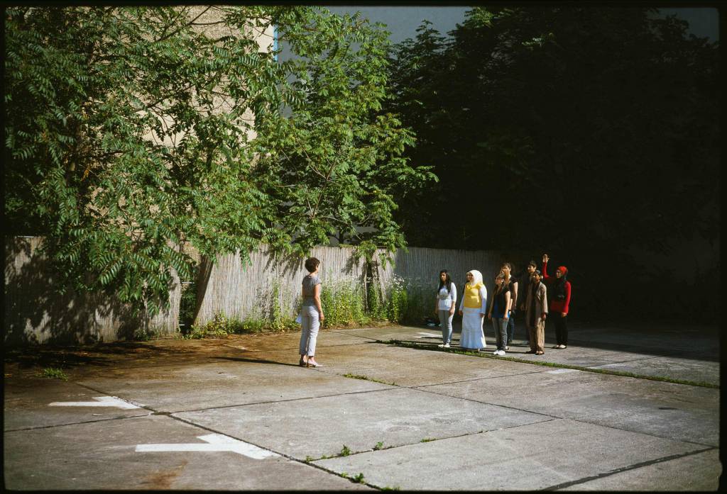 Students practicing a theater piece in a parking lot in Berlin